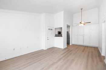 A room with a ceiling fan and wooden flooring.